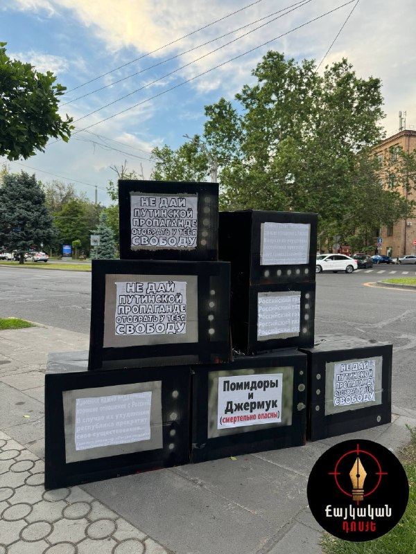 Инсталляции против российской пропаганды, включающие картонные телевизоры и окровавленную пешку, установленные в Ереване.